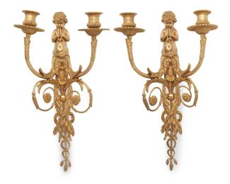 1314 A pair of Louis XVI style bronze wall sconces Henri Dasson (1825-1896), late 19th century Each impressed verso: NB 1809; 79 / 12 / 1212 / N1815 / 1813 / 1212 Each with a putto figure playing two horns above two lights, each issued from scrolling arms with foliate accents, above garlands and intertwined vines 2 pieces Each: 17.25" H x 8.75" W x 6" D Estimate: $1,000 - $2,000