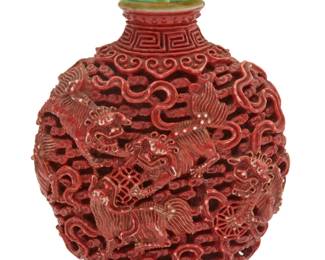 1133 A Chinese carved porcelain snuff bottle Jiaqing Period (1796-1820) or later With incised reign mark Depicting guardian lions playing with spheres 3.125" H x 2.25" W x 1.25" D Estimate: $700 - $900