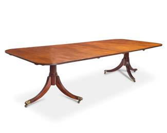 1377 A George III style mahogany twin pedestal extension dining table 20th century Each pedestal with applied label to underside: Made in England Each side raised on a three-legged pedestal terminating in brass paw feet, with two extensions Extended: 29.5" H x 120.5" W x 48" D; Each leaf: 24" W Estimate: $700 - $900