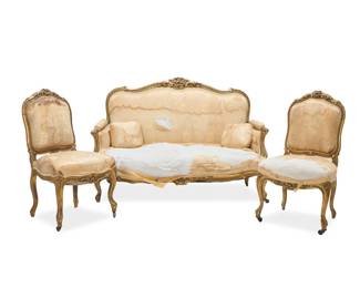 1086 A Louis XV style salon suite 19th/20th century Comprising a pair of side chairs and a settee, each with giltwood frame carved with foliate motifs, upholstered in a beige silk damask fabric 3 pieces Each chair: 38.25" H x 21.5" W x 23.5" D; Sofa: 41" H x 60" W x 32" D Estimate: $800 - $1,200