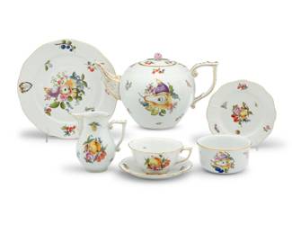 1284 A Herend porcelain 'Market Garden' tea service 20th century Each with blue printed factory mark, some with painted shape number and pattern Comprising: 1 teapot (6.375" H x 11" W x 7" D) 1 open sugar (2.25" H x 4.375" Dia.) 1 creamer (4.625" H) 7 teacups (2.125" H) 8 saucers (6") 6 luncheon plates (9") 6 bread & butter plates (6") 30 pieces Estimate: $700 - $900