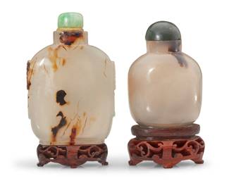 1143 Two Chinese carved agate snuff bottles Late Qing Dynasty (1644-1912) or later Each shadow agate raised on a carved wood stand, one with opposed beast masks in relief 2 pieces Taller: 3.25" H x 2.125" W x 0.75" D; Shorter: 2.625" H x 1.875" W x 1.25" D Estimate: $1,000 - $1,500