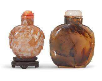 1141 Two Chinese carved agate snuff bottles Qing Dynasty (1644-1912) or later Comprising one butterscotch agate raised on a carved wood stand, and another agate bottle, each carved with opposed beast masks 2 pieces Larger: 3.375" H x 2.625" W x 1.125" D; Butterscotch: 2.75" H x 2" W x 1.125" D Estimate: $1,000 - $1,500
