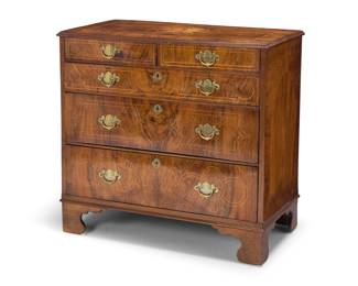 1353 A George I inlaid walnut chest of drawers Early 18th century with later elements The top inlaid with an eight-pointed star and crescents above two small drawers and three long locking drawers, each with later brass batwing escutcheons and lock plates, raised on bracket feet 36.75" H x 37" W x 22.5" D Estimate: $1,000 - $1,500