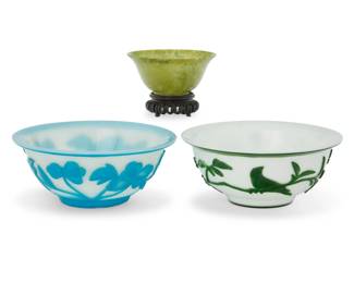 1168 Two Chinese glass overlay bowls and a carved jade bowl Late (1644-1912) or later Each overlay depicting floral motifs, the jade raised on a carved wood stand 3 pieces Larger overlay: 2.625" H x 6.25" Dia.; Jade: 1.75" H x 3.875" Dia. Estimate: $800 - $1,200