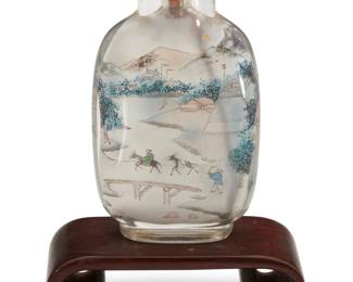 1134 A Chinese interior painted rock crystal snuff bottle Republic Period (1912-1949) Bearing signature of Ye Zhongsan and cyclical date likely to 1937 Depicting a mountain town scene, raised on a carved wood stand Bottle: 2.875" H x 1.625" W x 0.75" D; Stand: 0.75" H x 2.5" W x 1.125" D Estimate: $1,000 - $1,500