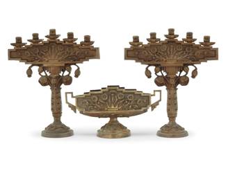 1114 An Art Deco gilt bronze three piece garniture Early 20th century Comprising a pair of five-light candelabra and a footed center bowl with metal liner, each depicting floral motifs 3 pieces Each candelabra: 20" H x 17.5" W x 6" D; Bowl: 9.5" H x 18" W x 6.375" D Estimate: $800 - $1,200
