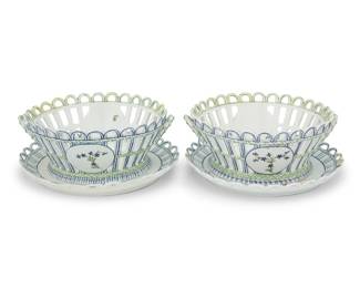 1183 A pair of Niderviller porcelain baskets and underplates Late 18th century Each element but one basket bearing a blue underglaze cipher to underside Each basket with latticework rim, opposed handles, and decorated with floral motifs, set on a matching underplate 2 pieces Each overall: 4" H x 9.75" Dia. Estimate: $500 - $700
