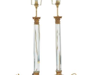 1385 A pair of Victorian gilt metal and glass table lamps Early 20th century with later fixtures Each with columnar glass standard issuing a single light, with gilt metal Corinthian capital and foliate-form base, electrified 2 pieces Each: 31.75" H x 6.375" W x 6.375" D Estimate: $300 - $400