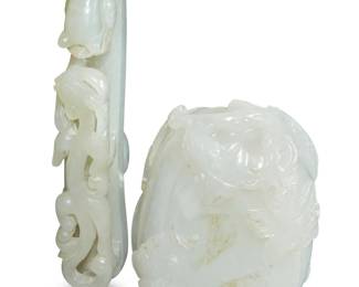 1164 Two Chinese carved jade articles 19th century or later Comprising a belt hook/buckle depicting a chilong figure, and a decorative item carved with a gourd, leaves, and a butterfly, together with an associated carved wood stand 2 pieces Belt hook: 3.625" L; Gourd: 2.5" H x 1.75" W x 1.375" D Estimate: $1,200 - $1,800