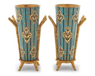 1296 A pair of French gilt bronze and champlevé enamel vases Attributed to F. Barbedienne foundry, circa 1890 Each appears unmarked Each vase decorated with foliate motifs, set in a gilt-bronze bamboo-form stand 2 pieces 8" H x 4.625" W x 3.25" D Estimate: $700 - $900