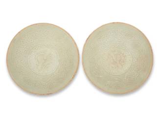 1027 A pair of Chinese molded ceramic qingbai bowls Yuan Dynasty (1271-1368) or later Each with pale green partial glaze, depicting birds and floral motifs within a meandering border 2 pieces Each: 1.625" H x 7.125" Dia. Estimate: $1,200 - $1,800