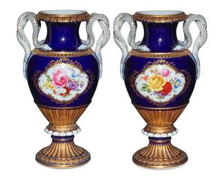 1213 A pair of Meissen porcelain baluster vases 20th century Each with underglaze blue cross swords; one impressed, the other incised: E153 Each painted with flowers in a cartouche on a cobalt blue ground with gilt elements, opposing snake-form handles, and a gadrooned base 2 pieces Each: 10.5" H x 6.375" W x 5.125" D Estimate: $800 - $1,200