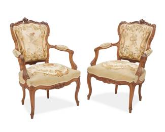 1080 A pair of Louis XV style fauteuils Early 20th century Each wood frame carved with acanthus leaves, with needlepoint upholstery, the seat backs depicting putti in a floral framework and the seats a suspended flower basket 2 pieces Each: 36.25" H x 26" W x 27.5" D Estimate: $400 - $600