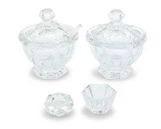 1393 A group of Baccarat glass table items Mid/late 20th century Each with etched factory mark Comprising two 'Harcourt Missouri' jam/jelly pots and one condiment pot, each housed in original packaging with foam inserts, two including glass spoons; a set of four hexagonal salt cellars with bone spoons paired into two original fitted boxes, two slightly larger conforming salt cellars, and a set of twelve octagonal salt cellars with bone spoons 21 pieces Larger jars: 5.625" H x 5.125" Dia.; Octagonal: 1" H x 2.25" Dia.; Boxes: 2" H x 6.375" W x 4.25" D Estimate: $200 - $400