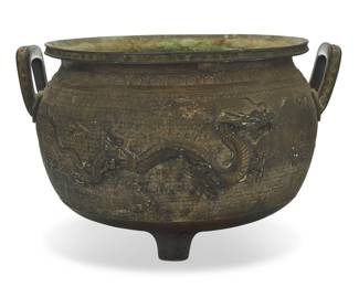 1047 A large Japanese bronze jardinere Meiji Era (1868-1912) or later With impressed seal to underside With opposed handles, the body decorated with dragons and clouds in relief on a meandering ground, raised on three feet, the underside incised with cloud motifs 13.25" H x 21.5" W x 19.75" D Estimate: $1,000 - $1,500