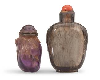 1144 Two Chinese carved quartz snuff bottles Qing Dynasty (1644-1912) or later Comprising one gourd-form amethyst bottle carved with foliate motifs, and one rutilated smoky quartz bottle 2 pieces Amethyst: 2" H x 1.125" Dia.; Smoky: 2.75" H x 1.75" W x 0.875" D Estimate: $1,000 - $1,500