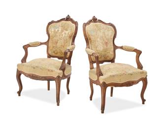 1081 A pair of Louis XV style fauteuils Early 20th century Each wood frame carved with acanthus leaves, with needlepoint upholstery, the seat backs depicting couples in a landscape, the seats with flowers and foliage 2 pieces Each: 38" H x 26.5" W x 27.5" D Estimate: $400 - $600