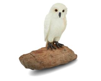 1251 A carved white agate owl on petrified wood base Late 20th century With inset glass eyes Overall: 5.375" H x 5.375" W x 2.75" D Estimate: $600 - $800