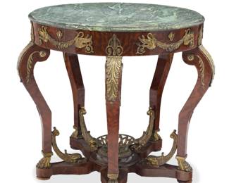 1085 An Empire style bronze-mounted mahogany center table Late 19th/early 20th century With green marble top, mounted with palmettes, swans, dolphins, and paw feet, raised on five cabriole legs joined by a stretcher centered by a reticulated basket 34.75" H x 41" Dia. Estimate: $800 - $1,200