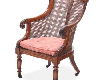 1333 A William IV caned mahogany armchair Circa 1820 With caned seat and back, sloping armrests ending in scrolls, later upholstered seat cushion, on ring-turned legs raised on casters 37" H x 23" W x 30" D Estimate: $800 - $1,200