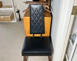 A rare mid-century modern gentleman's tuxedo silent valet chair upholstered in a tufted black vinyl fabric on peg legs.