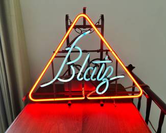 A highly collectible vintage Blatz Beer neon sign fully functioning with vibrant orange and turquoise text.