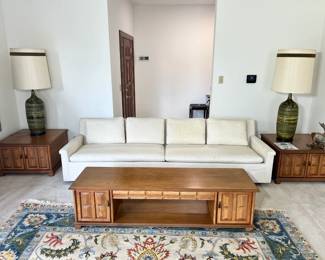 Mid-Century Modern Sofa: A pristine, low-profile cream/off-white textured upholstery sofa resting on a clean walnut base.