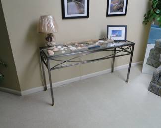 Another glass and metal side table filled with seashells
