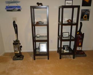 A pair of shelving units and a pair of vacuums