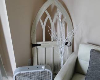 The arched art piece would look equally attractive on the wall. The box fan, just let that one sit on the floor