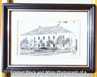 Framed Black and White Photograph of a Building with a Statue and a Person on a Bicycle