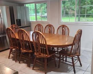 Beautiful solid wood dining room set in very good condition. Includes: Large expandable dining table 8 matching chairs Built-in leaf extension Very sturdy and well cared for. Perfect for large families, holiday gatherings, Airbnb, farmhouse, or country-style homes. Table has a warm oak finish with a classic timeless look that fits both rustic and traditional spaces. Chairs are solid and comfortable with elegant spindle backs.
