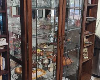 Elegant Lighted China Cabinet / Curio Display Cabinet Beautiful traditional china cabinet with glass shelving, mirrored back, and decorative glass-pane doors. Excellent for displaying crystal, china, collectibles, books, or décor. Features: Interior lighting Glass shelves Mirrored backing Rich wood finish Large storage/display capacity Elegant traditional styling Very clean presentation and well cared for. China wares not included. $695