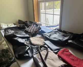 A table covered in a variety of purses.