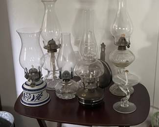 A table of vintage kerosene lamps.