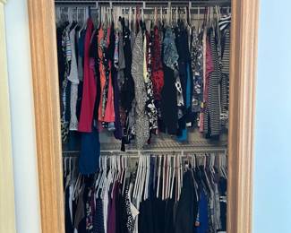 A glimpse into the main closet, absolutely filled with clothes.