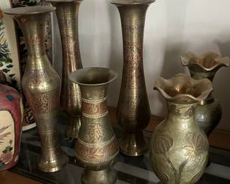 A collection of metal vases, each with similar designs.