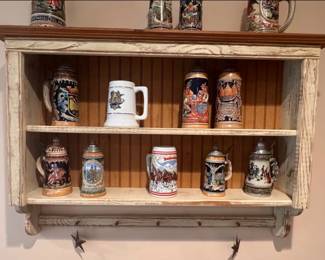 Collection of beer steins and farmhouse-style wall cabinet with pegs