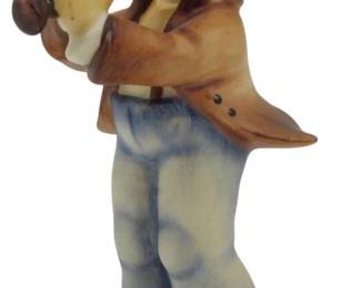 562 - Hummel Serenade Boy w/ Clarinet Figure 5" (Description): Hummel "Serenade" figurine depicting a young boy playing a clarinet. The charming figure shows a blonde child wearing a brown coat, blue trousers, and a gray top hat with red trim. He stands on a cream-colored circular base in a classic Hummel styl. Measures 5 inches tall.