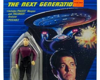 555 - Galoob Star Trek TNG Commander Riker Figure (Description): Unopened Galoob Star Trek: The Next Generation action figure in original packaging. This collectible features Commander William Riker, the 'Number One' Officer of the U.S.S. Enterprise Starship. The figure remains sealed in its original box.