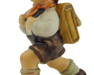 560 - Hummel School Boy Figure 4.5" (Description): Hummel School Boy figurine depicting a cheerful young boy in traditional Bavarian attire, striding along with a satchel on his back. He wears a blue alpine hat with a feather, white shirt with orange neckerchief, brown lederhosen, striped knee socks, and brown shoes. The hand-painted porcelain figure stands on a cream-colored oval base. Measures 4.5" tall.