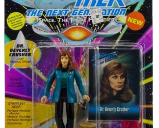 546 - Playmates Star Trek TNG Dr. Beverly Crusher (Description): Unopened Playmates Star Trek The Next Generation action figure in original packaging featuring Dr. Beverly Crusher, Chief Medical Officer. The figure includes bonus Starfleet Action Base and Starfleet Gear accessories including Portable Medical Monit