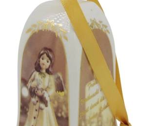 566 - Goebel Annual Christmas Bell 2013 (Description): 2013 Goebel Annual Christmas Bell featuring a charming Hummel-style angel figure holding a small bird. The white porcelain bell displays the angel within an arched frame decorated with gold leaf accents at the top. The bell includes a gold satin ribbon hanger and is dated 2013 at the base. Measures 4" tall.