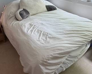 Queen Size Bed Frame with White Ruffled Bed Skirt and Decorative Pillows