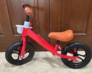 Red Balance Bike with White Basket and Brown Grips