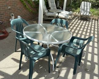 Glass Top Patio Dining Set with 4 Green Plastic Chairs