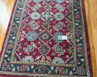 Lot 2: Hand-tufted wool rug with burgundy field and ornate border