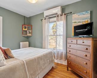 twin bed and vintage antique dresser, tv, art