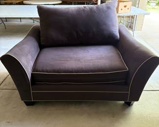 Dark leather club chair with wide modern arms